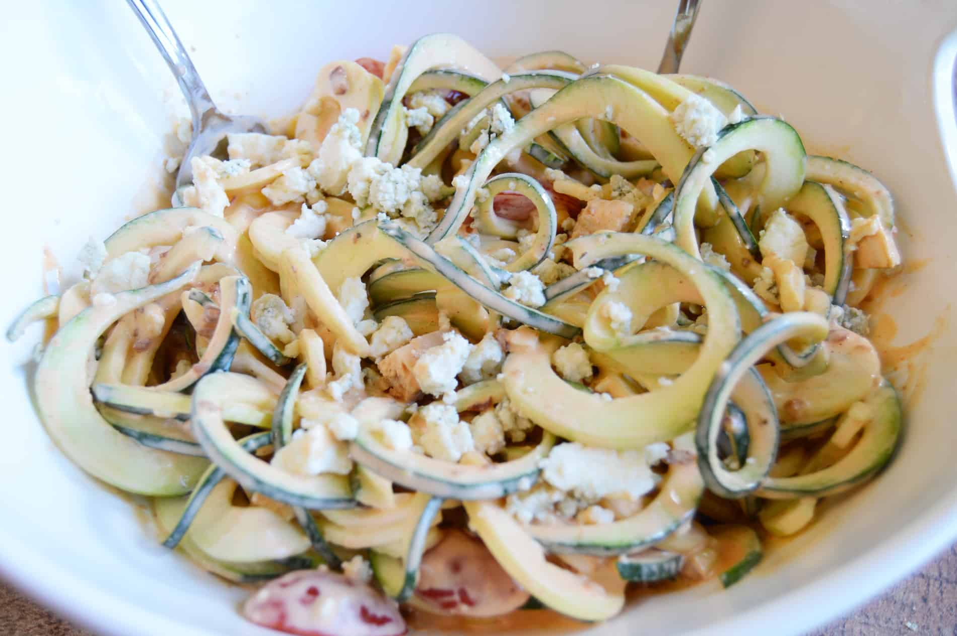 Spiralized zucchini salad made with chicken, Jimmy's Blue Cheese, tomatoes, bacon and corn in white bowl